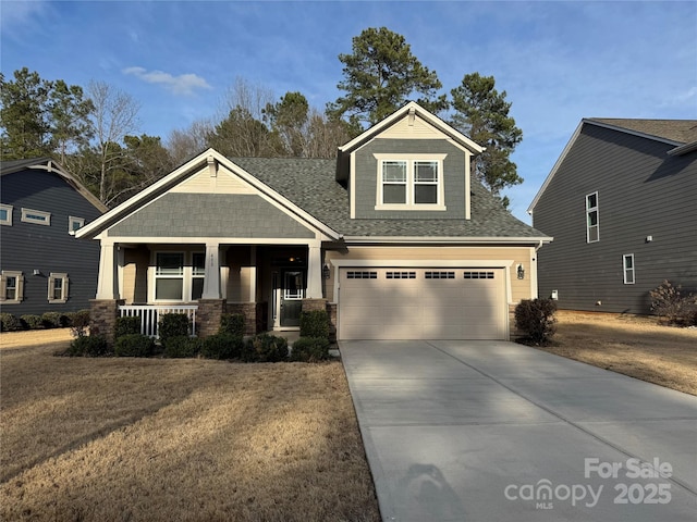 craftsman inspired home featuring roof with shingles, a porch, concrete driveway, a garage, and stone siding