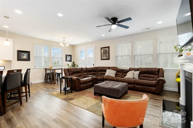 living area featuring light wood-style floors, recessed lighting, and visible vents