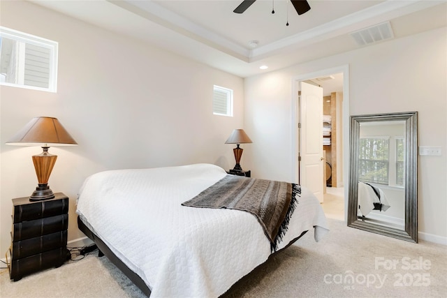 bedroom with a tray ceiling, visible vents, carpet flooring, ceiling fan, and baseboards