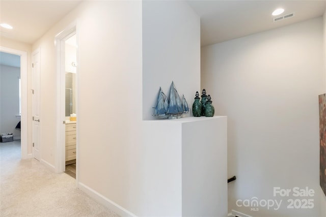 corridor with recessed lighting, visible vents, baseboards, and light colored carpet