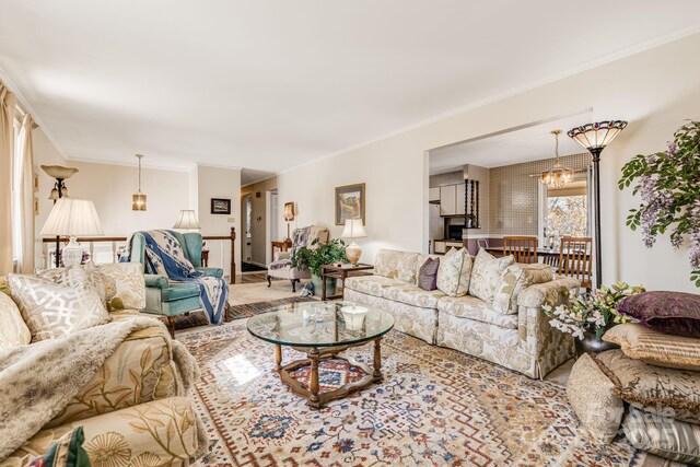 living area featuring a chandelier and crown molding