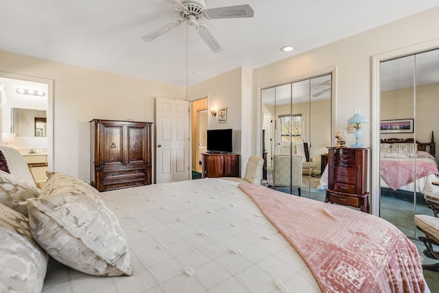 bedroom featuring connected bathroom, a ceiling fan, and multiple closets