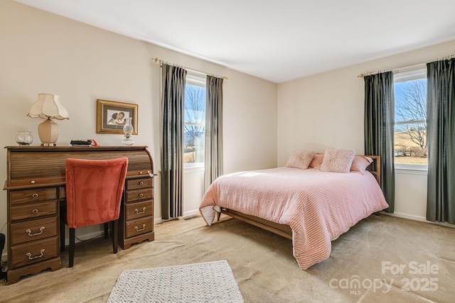 bedroom with baseboards and light colored carpet