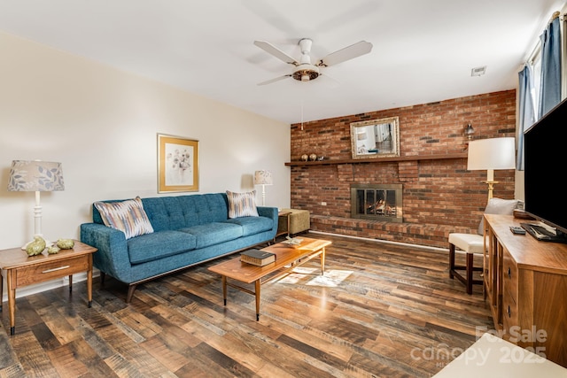 living room with brick wall, a fireplace, a ceiling fan, and wood finished floors