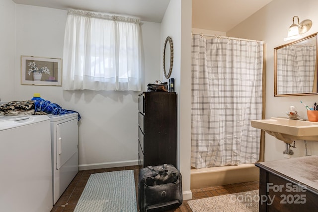 bathroom featuring baseboards, shower / bath combo with shower curtain, and independent washer and dryer