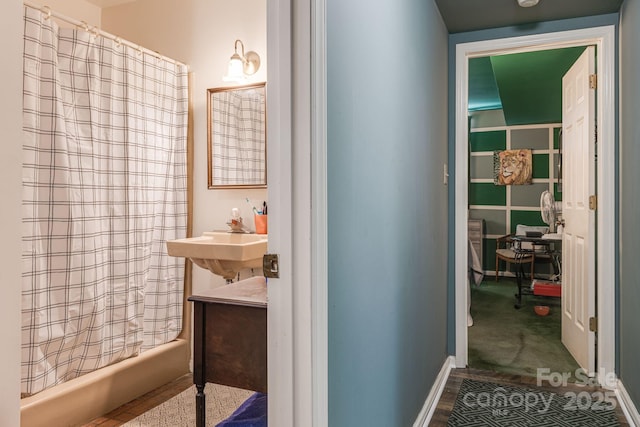 bathroom featuring shower / bath combination with curtain and a sink