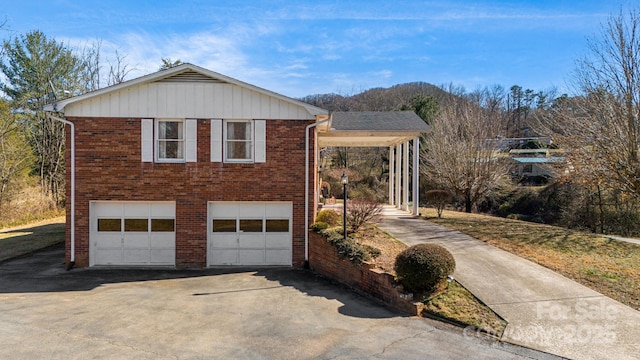 exterior space featuring concrete driveway, brick siding, and an attached garage