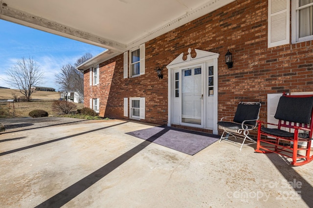 view of exterior entry with brick siding