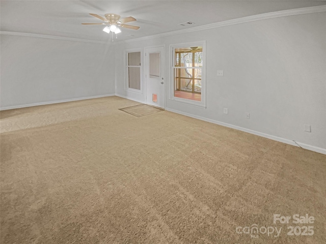 unfurnished room featuring ornamental molding, carpet flooring, visible vents, and baseboards