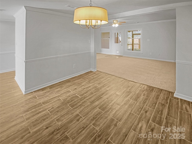 spare room featuring a ceiling fan, baseboards, ornamental molding, and wood finished floors