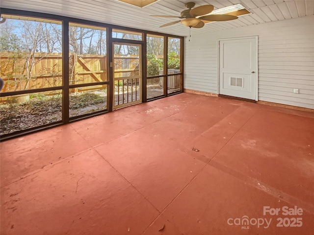 unfurnished sunroom featuring wooden ceiling and a ceiling fan