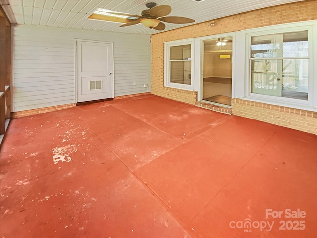 unfurnished sunroom featuring ceiling fan