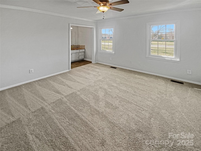 unfurnished bedroom featuring baseboards, carpet, visible vents, and crown molding