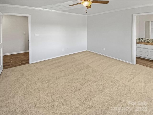 unfurnished bedroom with carpet floors, baseboards, ornamental molding, and a ceiling fan