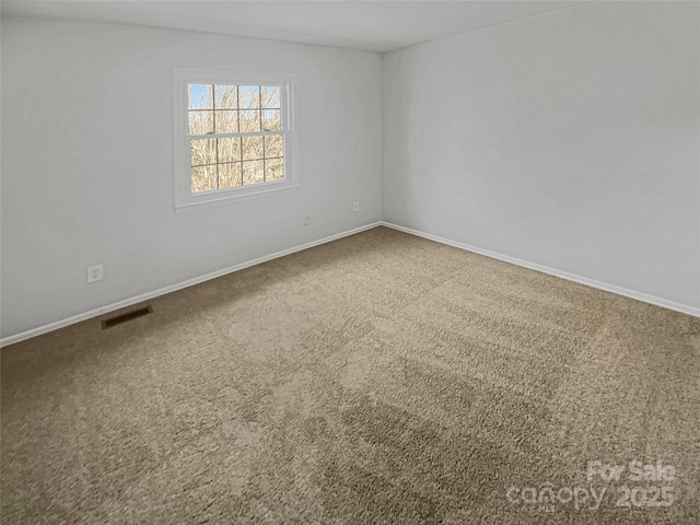 empty room featuring carpet floors, baseboards, and visible vents