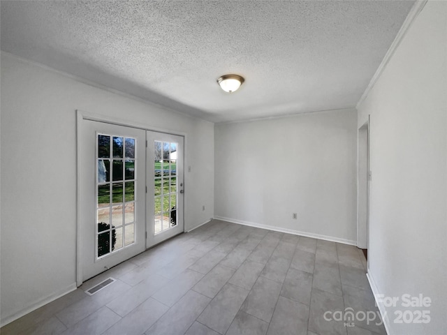 unfurnished room with a textured ceiling, french doors, visible vents, and baseboards