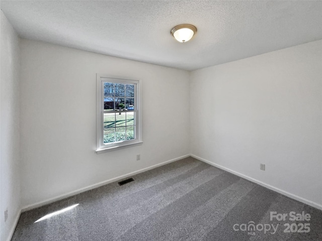 carpeted empty room with a textured ceiling, visible vents, and baseboards