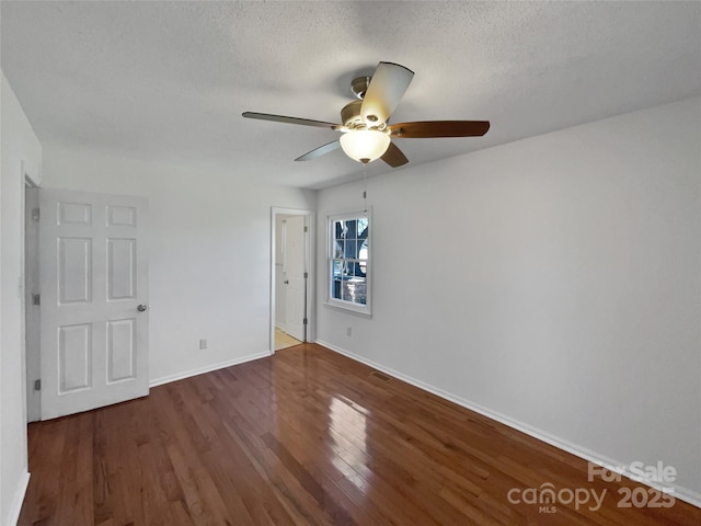 unfurnished bedroom featuring a ceiling fan, dark wood finished floors, a textured ceiling, and baseboards