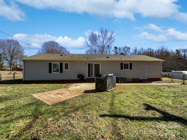 back of property with fence, a patio, and a yard