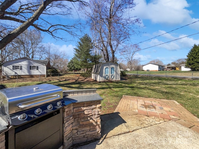 view of yard with a storage shed, fence, an outbuilding, and a patio