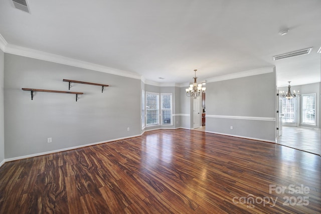 spare room with wood finished floors, visible vents, and a notable chandelier