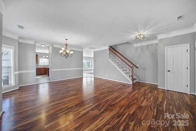 unfurnished living room featuring stairway, wood finished floors, a wealth of natural light, and an inviting chandelier