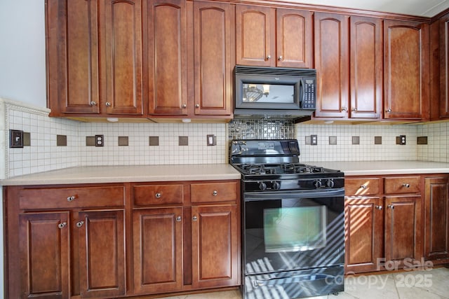 kitchen featuring reddish brown cabinets, black appliances, light countertops, and backsplash