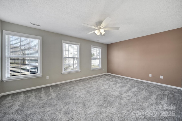 empty room featuring ceiling fan, carpet floors, visible vents, and baseboards