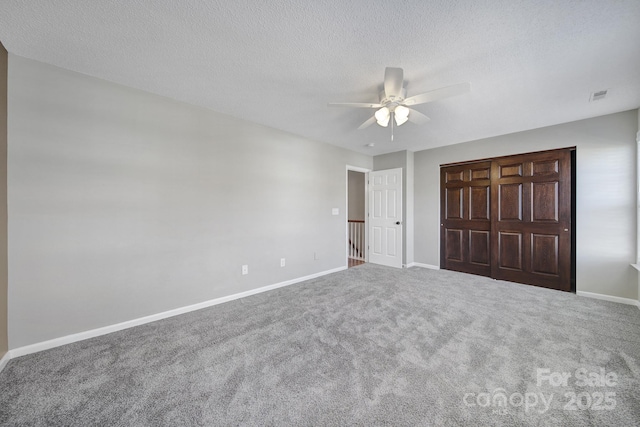 unfurnished bedroom with carpet, baseboards, visible vents, and a textured ceiling