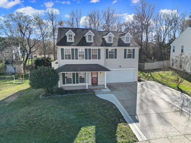 view of front facade with an attached garage, driveway, a front yard, and fence