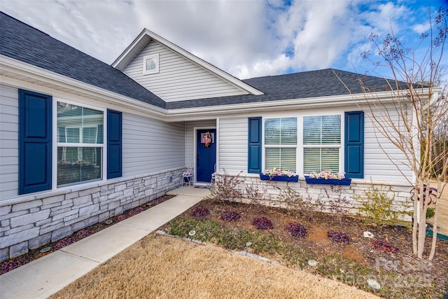 view of front of house with stone siding and a shingled roof