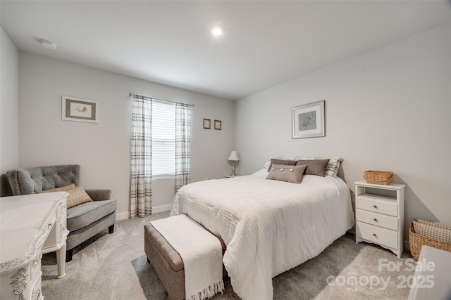 bedroom with light colored carpet and baseboards