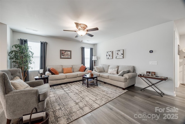 living room featuring ceiling fan, wood finished floors, visible vents, and baseboards