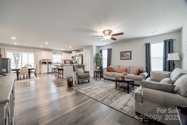 living area featuring ceiling fan, light wood-type flooring, plenty of natural light, and recessed lighting