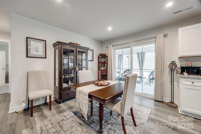 dining area with light wood-style floors, recessed lighting, visible vents, and baseboards