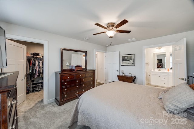 bedroom with light carpet, visible vents, ensuite bathroom, a spacious closet, and a closet