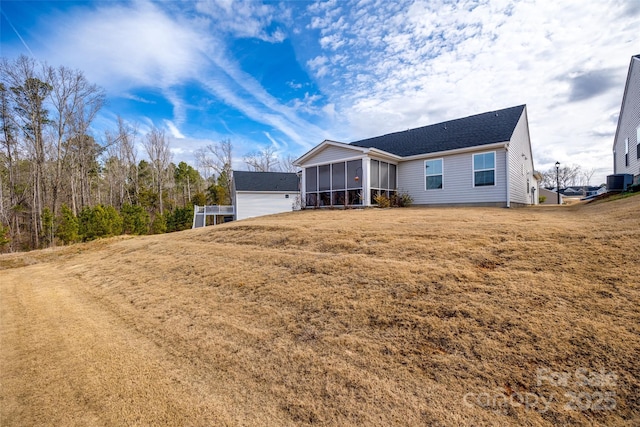 single story home with central AC unit, a front lawn, and a sunroom