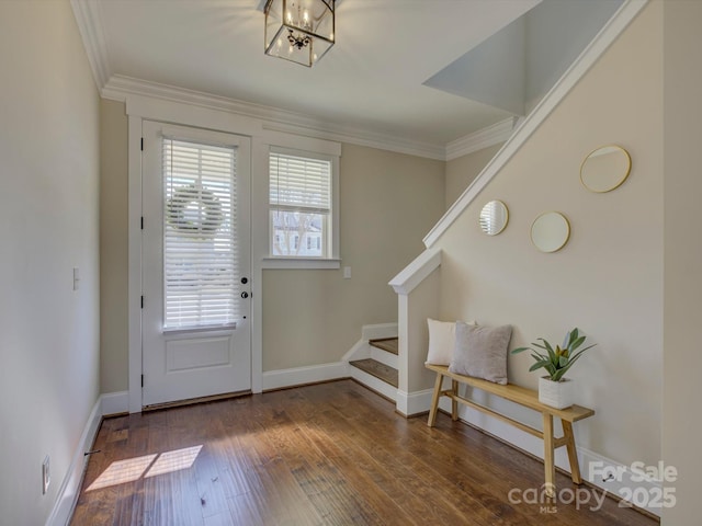 entryway featuring ornamental molding, wood-type flooring, baseboards, and stairs