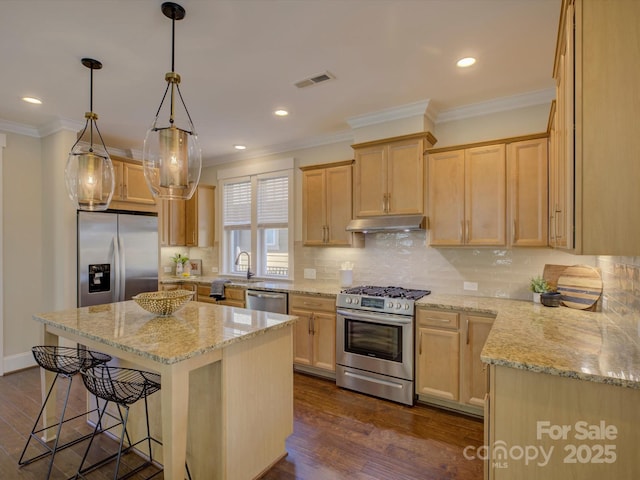 kitchen with under cabinet range hood, dark wood-style flooring, visible vents, appliances with stainless steel finishes, and a kitchen bar