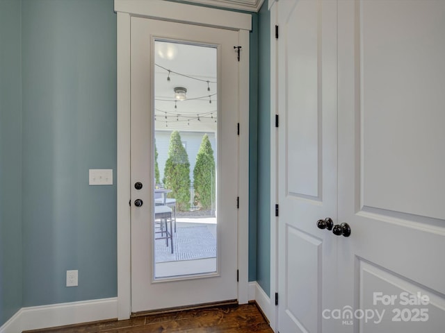 doorway with baseboards and dark wood finished floors