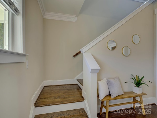 stairway featuring ornamental molding, wood finished floors, and baseboards