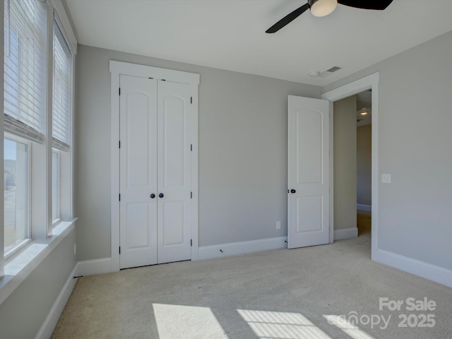 unfurnished bedroom featuring carpet floors, baseboards, and a ceiling fan