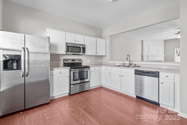 kitchen with wood finished floors, light countertops, appliances with stainless steel finishes, and a sink