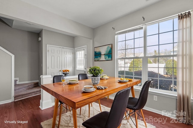 dining space featuring wood finished floors, baseboards, and stairs