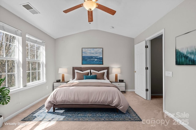 bedroom featuring lofted ceiling, baseboards, light carpet, and visible vents