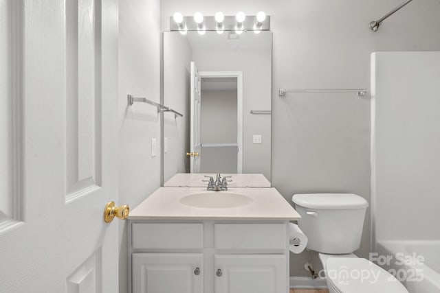 bathroom featuring toilet, shower / bathing tub combination, and vanity