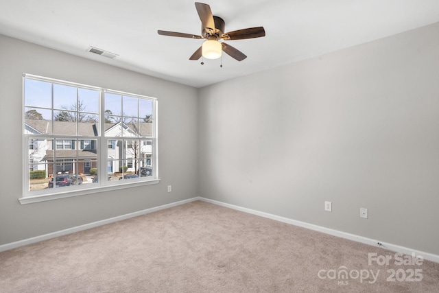 empty room featuring ceiling fan, carpet, visible vents, and baseboards