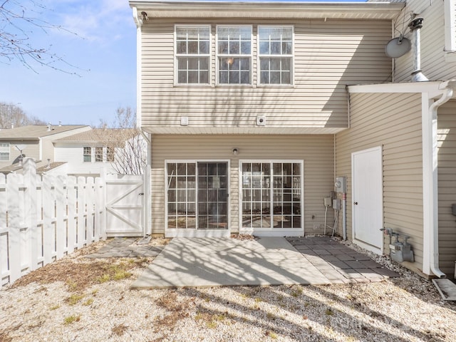 back of house with a gate, fence, and a patio