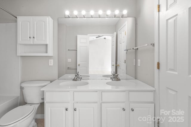 bathroom featuring a sink, toilet, and double vanity