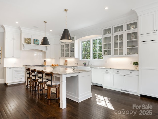 kitchen featuring dishwasher, a center island with sink, and white cabinetry